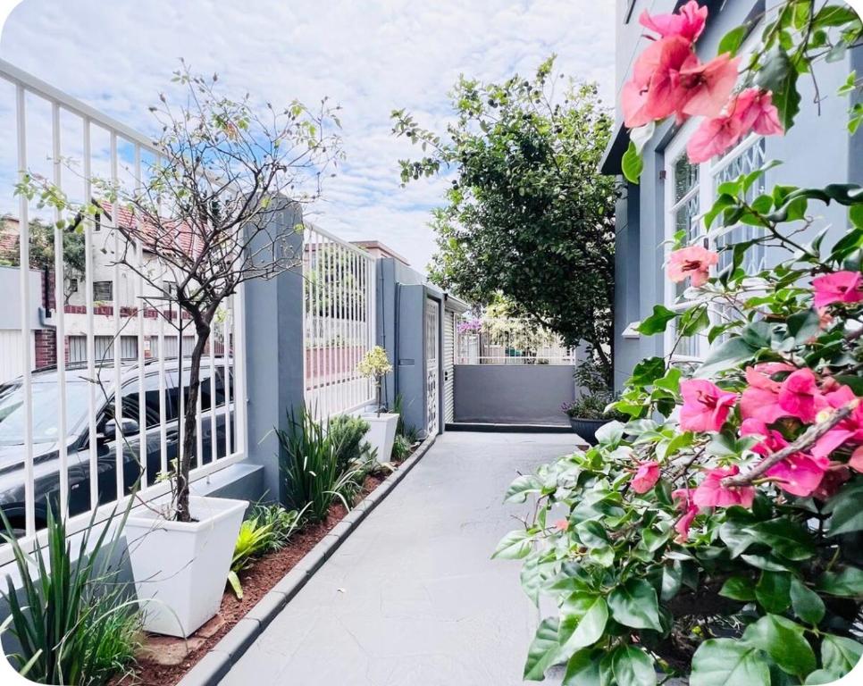 a walkway with pink flowers on the side of a building at Heaven on Windermere in Durban