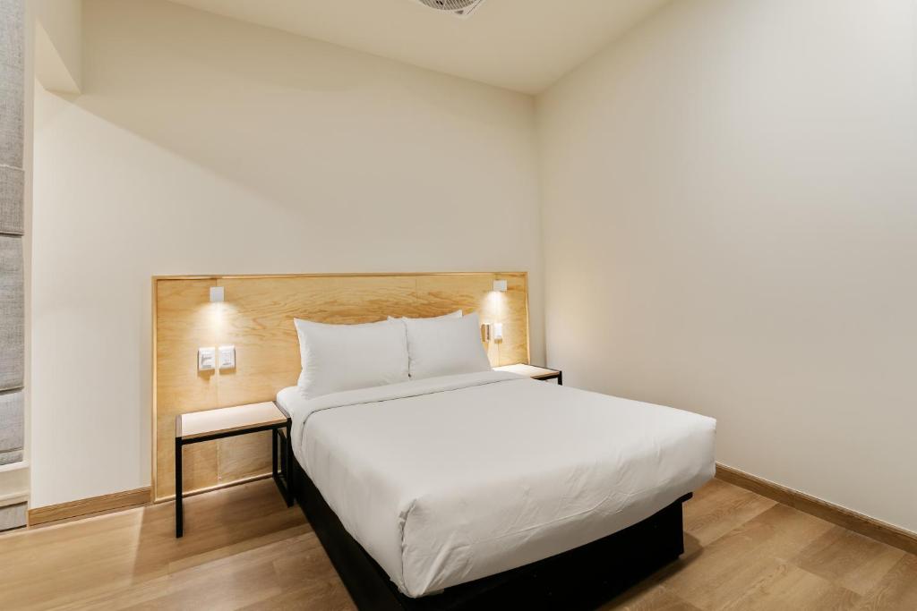 a bedroom with a large white bed in a room at Madero By Homirent in Querétaro