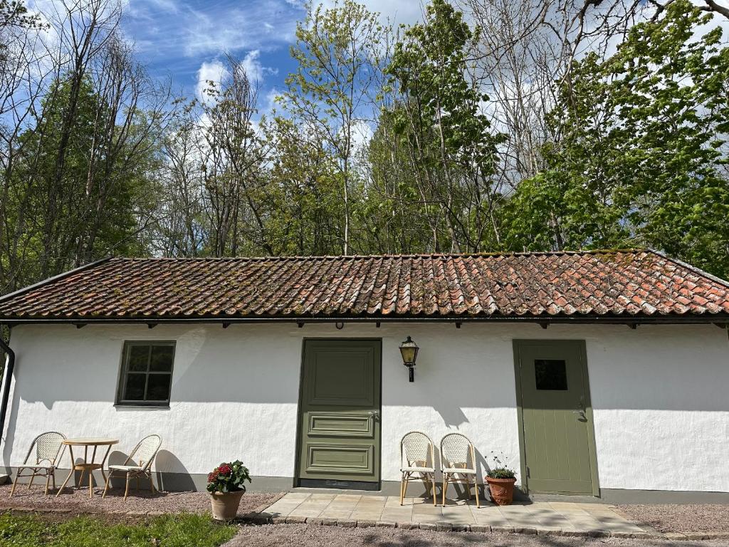 a white house with chairs and a table and chairs at Orangeriet Björkelund in Skövde