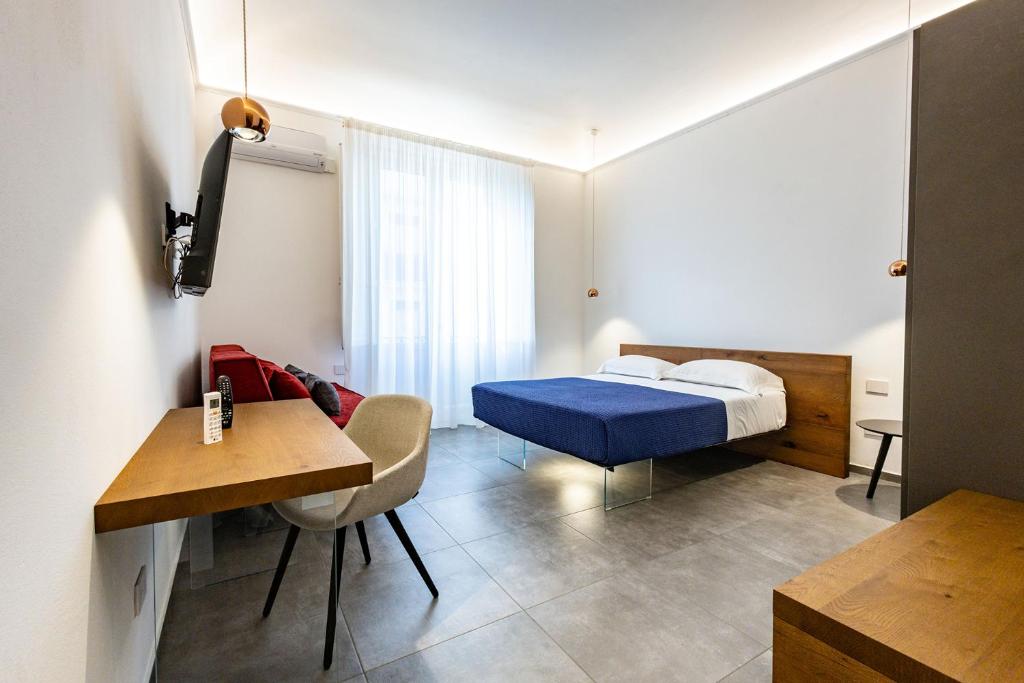 a bedroom with a bed and a desk and a table at 32Venti - Comfort Apartments Trapani in Trapani