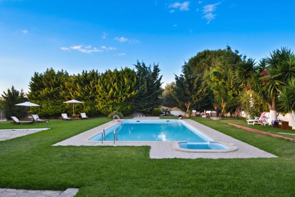 a swimming pool in a yard with grass and trees at Villa John Dimeon Kato Achaia With Pool - Happy Rentals in Patra