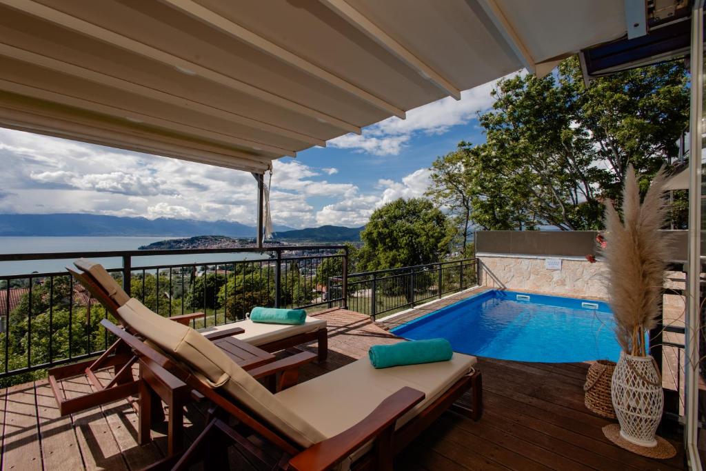a patio with a pool and chairs and a swimming pool at Villa Aurora in Ohrid