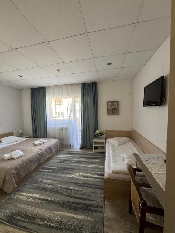 a hotel room with two beds and a television at Vila Ispirescu INN in Cluj-Napoca