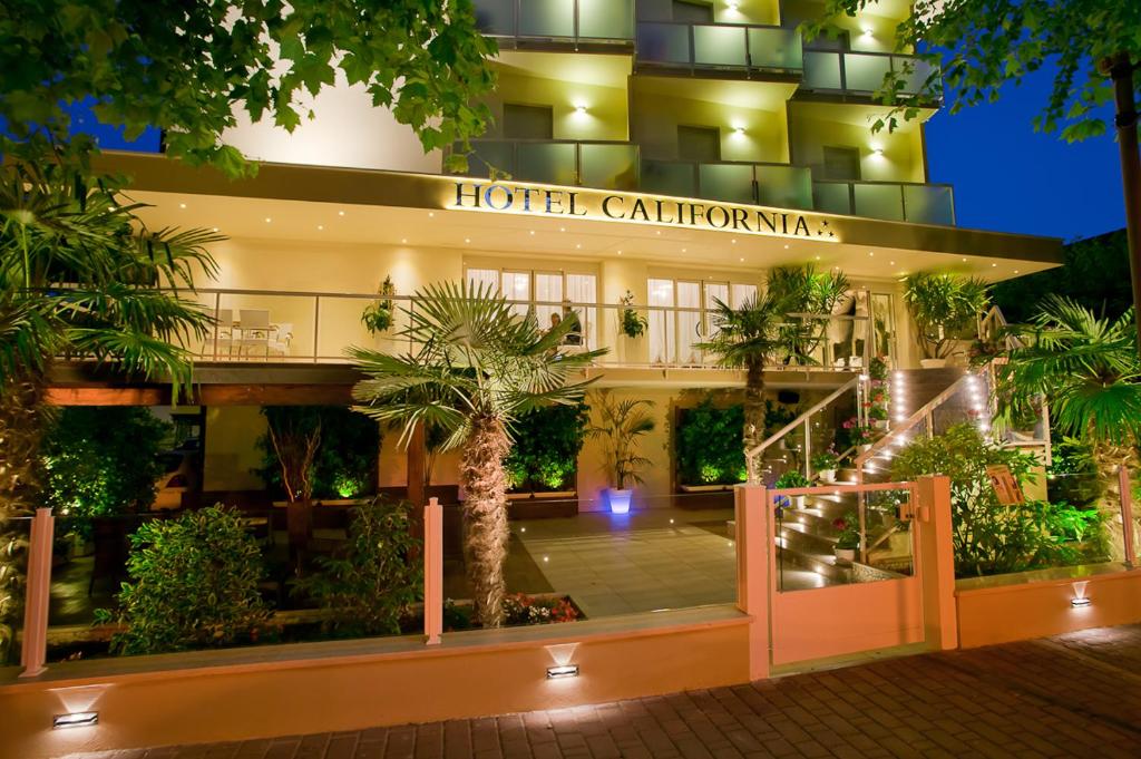 een hotelingang met palmbomen ervoor bij California Pastry Hotel in Cervia