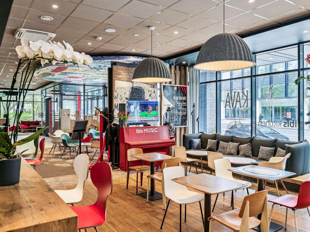 a restaurant with tables and chairs and windows at ibis Vilnius Centre in Vilnius