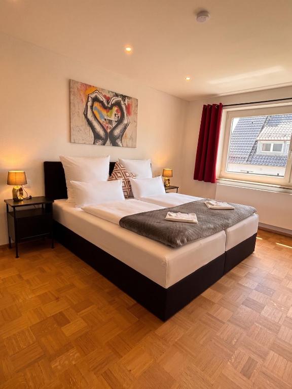 a bedroom with a large bed with white pillows at Moderne Ferienwohnung in Jettingen-Scheppach