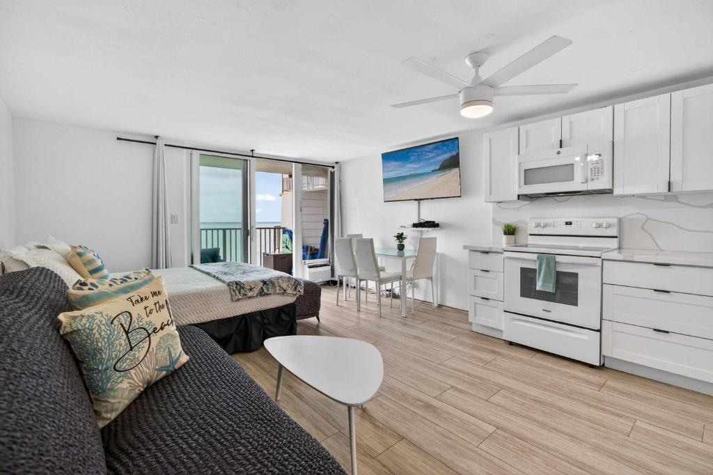 a living room with a couch and a kitchen at Luxury Beachfront Condo in Hauula
