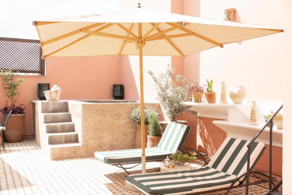 two chairs and an umbrella on a patio at Riad Lamzia in Marrakesh