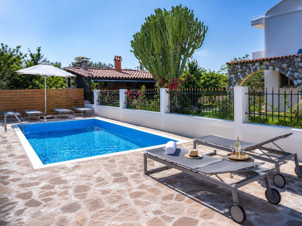 a swimming pool in a backyard with a fence at Villa Elysian Private pool & garden view in Antimácheia