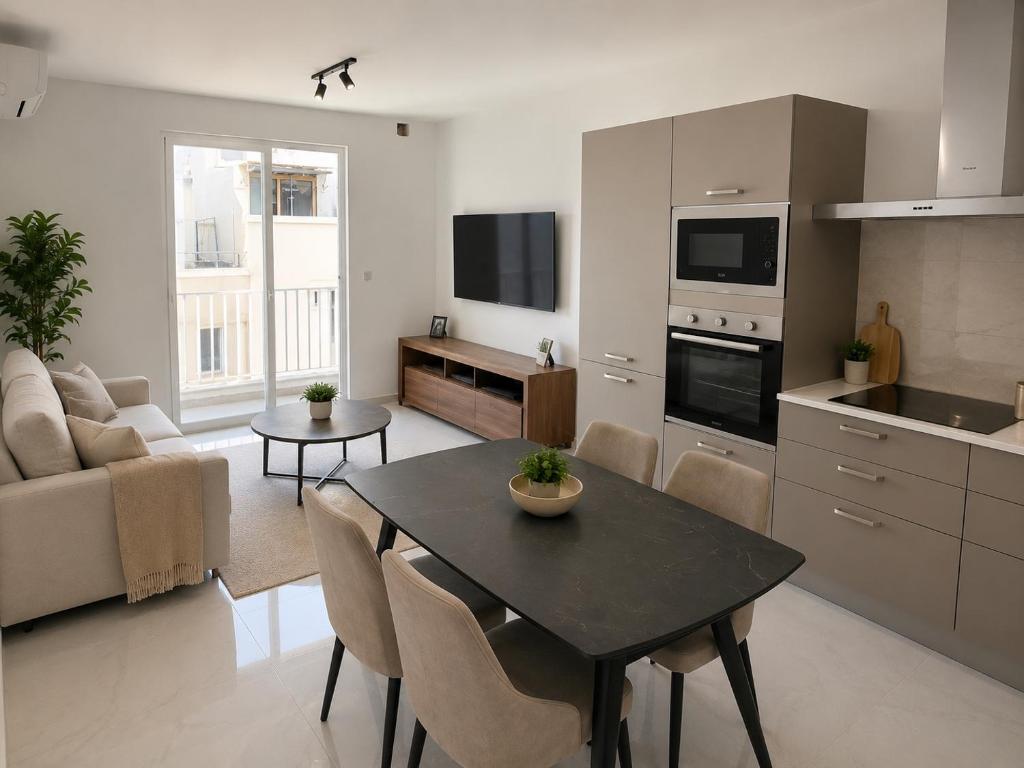 a kitchen and a living room with a table and chairs at Luna Suites in St. Julianʼs