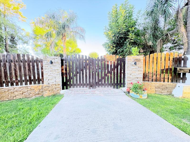 a wooden fence with a pathway in a yard at Los Nardos in San Nicolás de los Arroyos