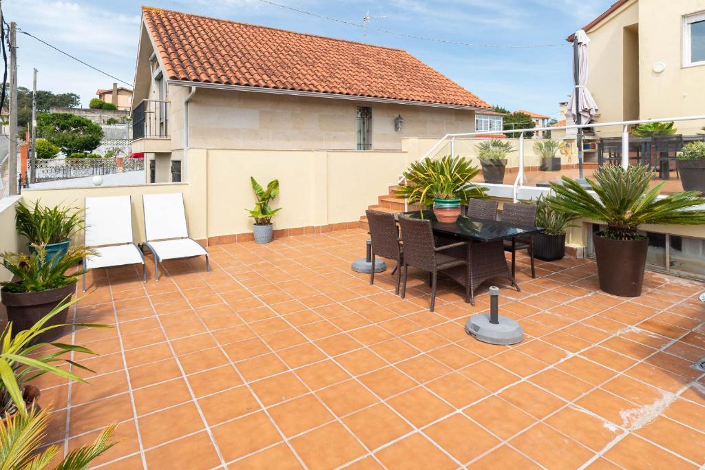a patio with a table and chairs on a house at Atico Solpor Patos in Nigrán