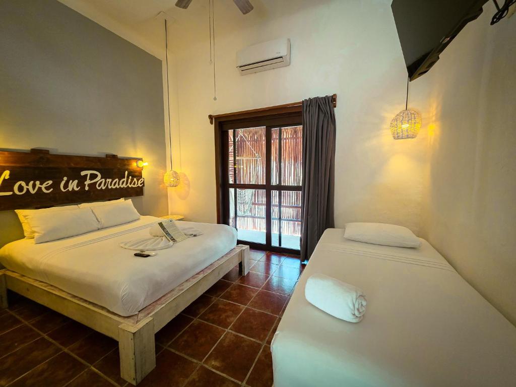 a bedroom with two beds and a window with the words love in paradise at 40 Cañones in Mahahual