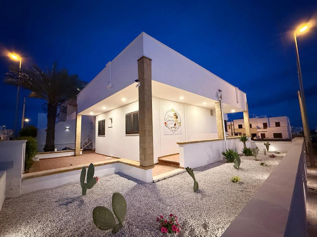 a white house with cacti in front of it at night at Donna Ginevra Rooms - A soli 300m dalla Spiaggia in Lido Marini