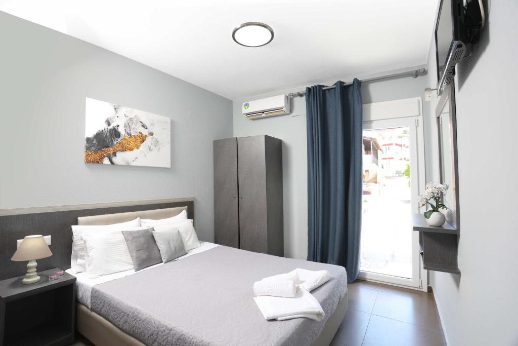 a bedroom with a bed and a window at Soluna Studios in Polychrono
