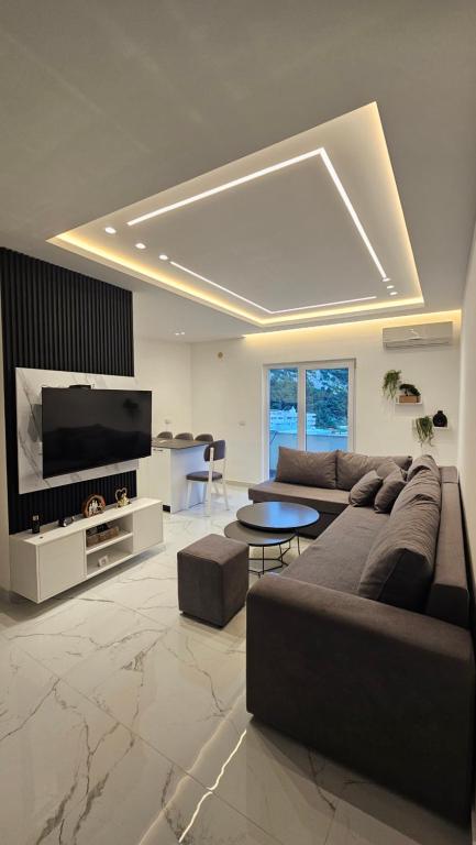 a living room with a couch and a tv at DLE Murtic in Shëngjin