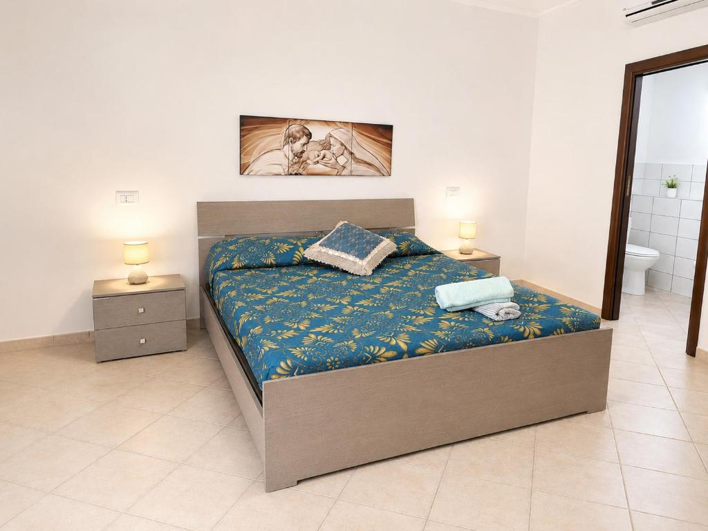 a bedroom with a bed with two night stands and two lamps at HOUSE IN PARADISE - Realmonte with Free parking in Realmonte