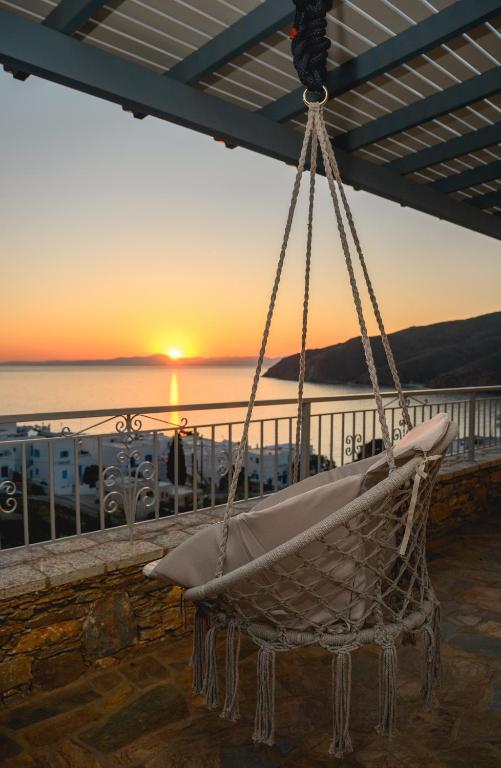 a hammock hanging from a balcony with a sunset at Villa Markiani in Aegiali