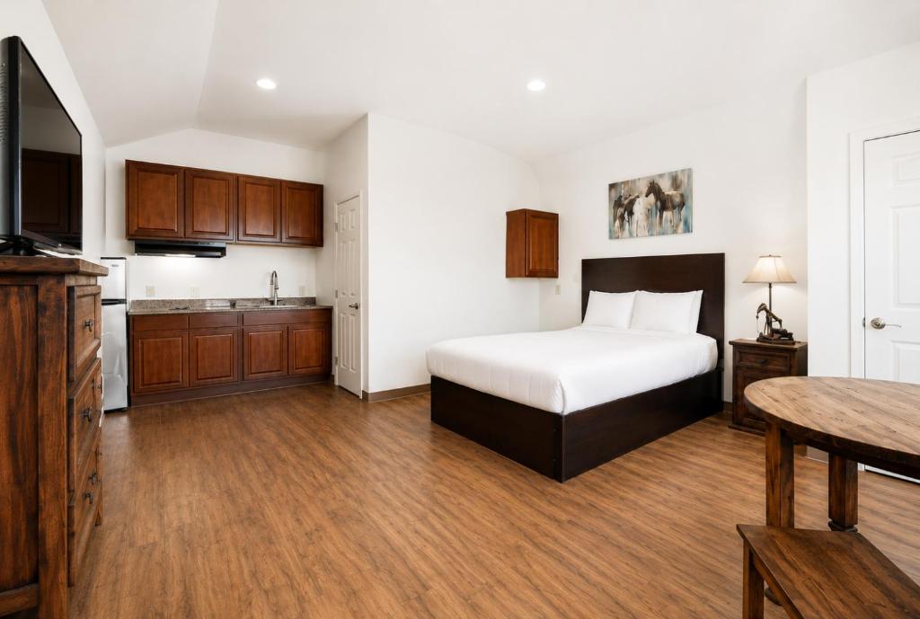 a hotel room with a bed and a kitchen at The Resource Inn Big Lake in Big Lake