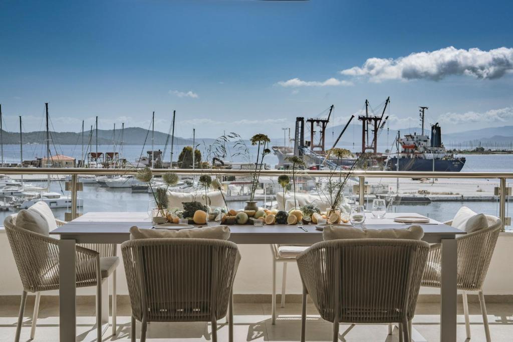 a table with chairs and a view of a harbor at Akari - Luxury Apartment in Preveza