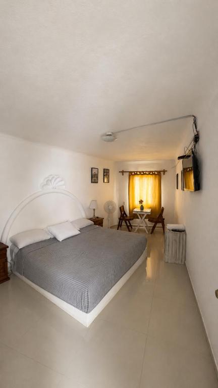 a bedroom with a large bed in a white room at Hotel Casa Xicun in Tepoztlán