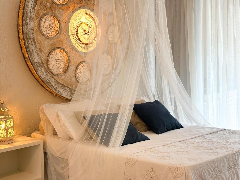 a bedroom with a bed with a canopy and a window at Loft Caeté in Araruama