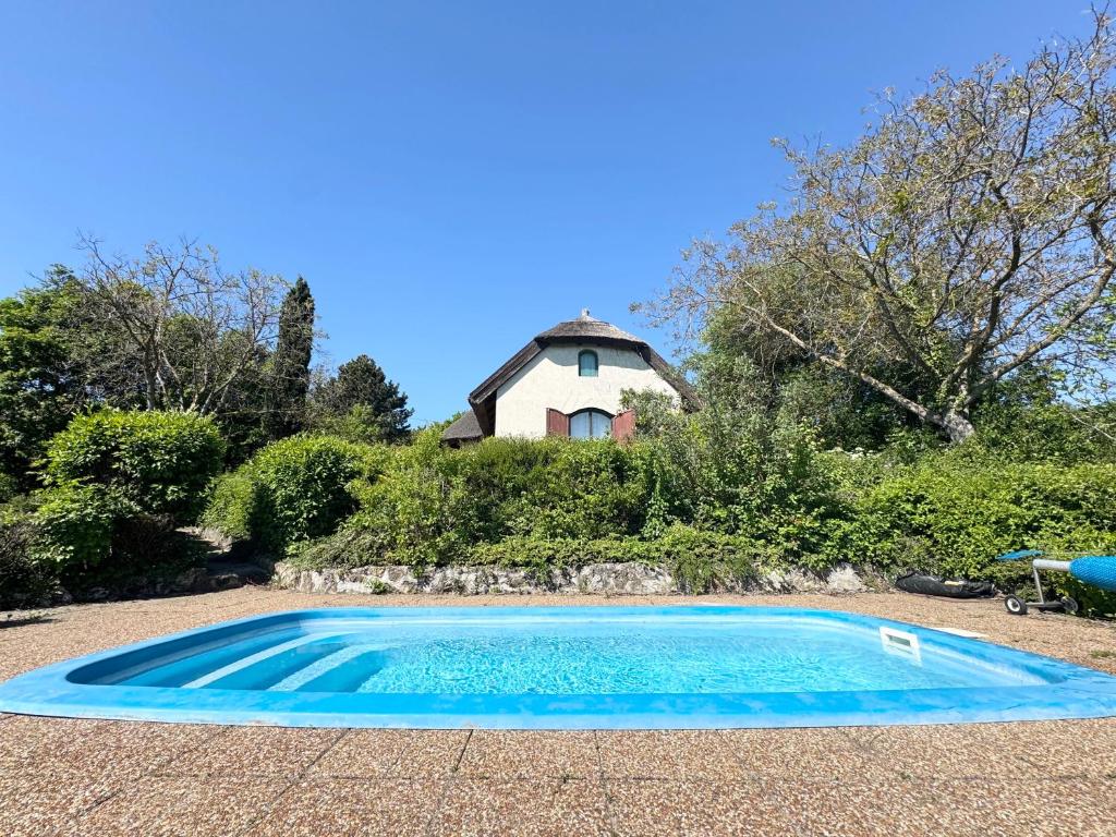 an empty swimming pool in front of a house at Szaletli in Tihany