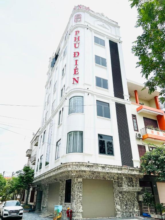a white building with a red sign on it at Phú Điền Motel in Ðại Sơn