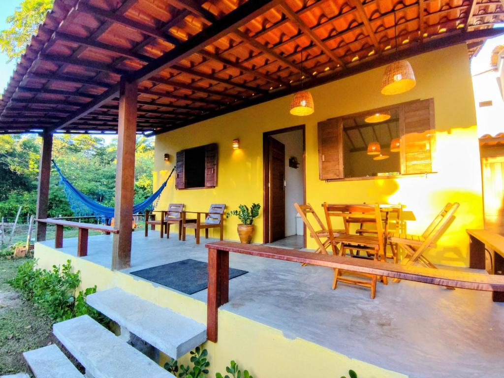 a patio with a table and chairs on a house at Casa Cajá - praia, natureza & conforto em Boipeba in Ilha de Boipeba
