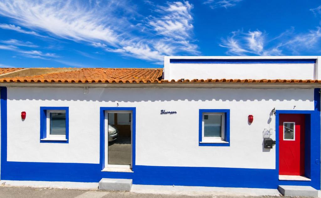 a white and blue house with a red door at Bluemoon Campinho Rooftop & BBQ near Alqueva in Campinho