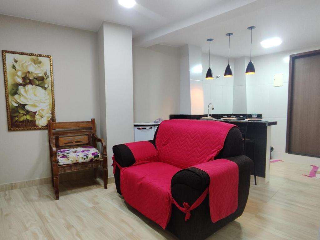 a red chair in a room with a table at Recanto dos sabias AP01 in Conservatória