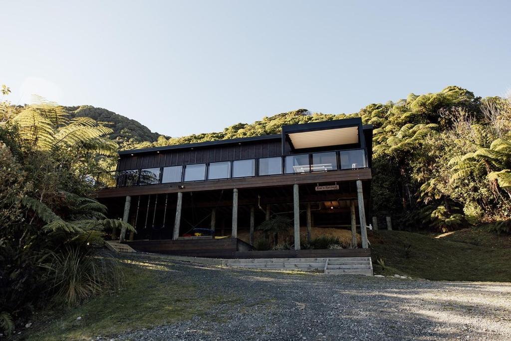 a house on a hill with a road in front of it at Kais Retreat in Punakaiki