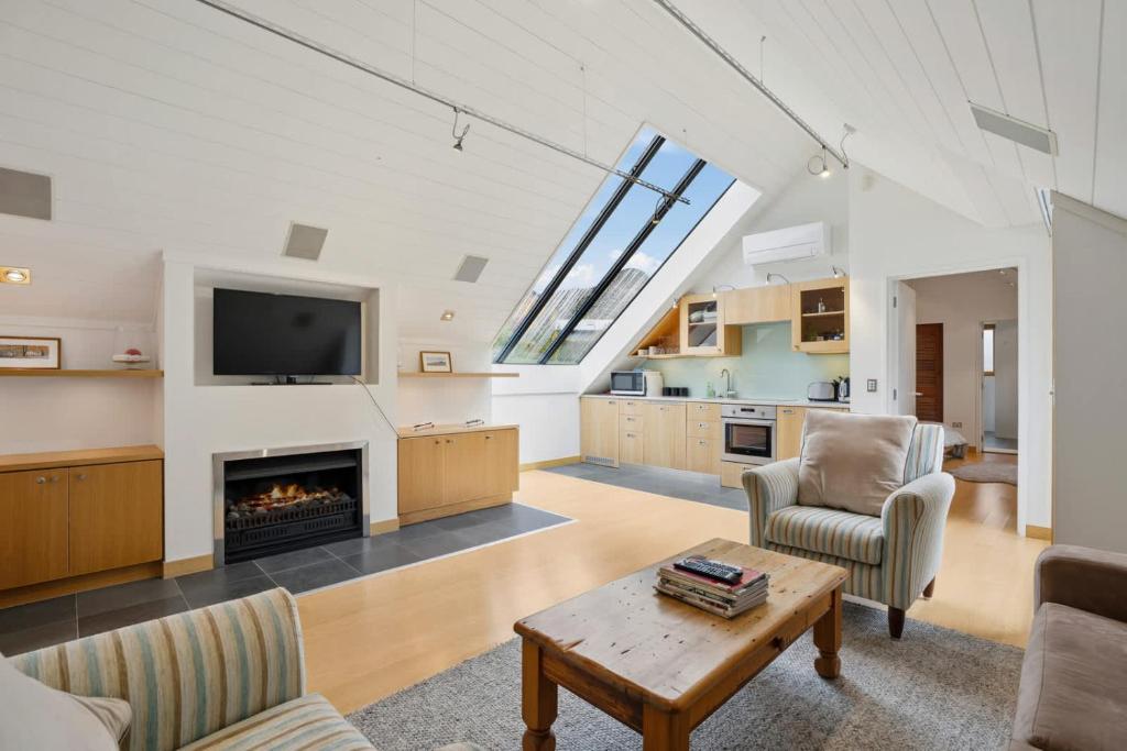 a living room with a fireplace and a tv at Gibbston Hideaway in Gibbston