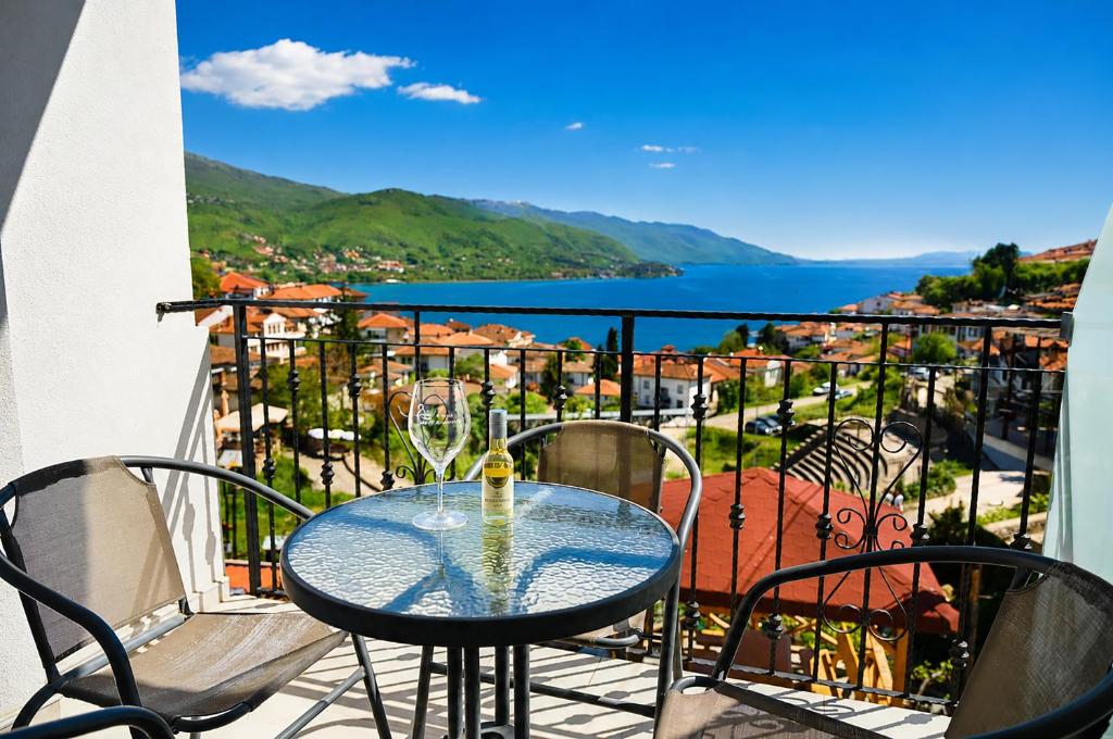 a table and chairs on a balcony with a view at Apartments NOCE - Premium Lake View in Ohrid