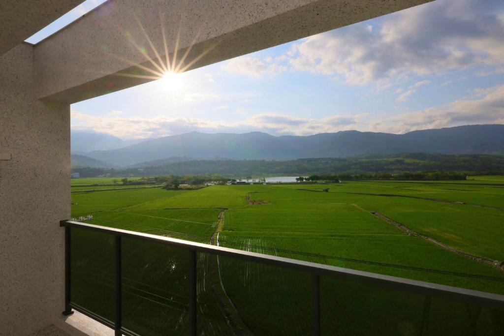 a view of a green field from a balcony at Go Chishang B&B in Chishang