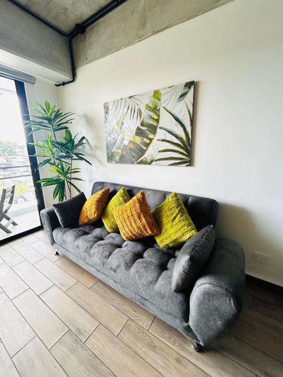 a black couch with yellow pillows in a living room at Cozy Apartment 4 degrees north in Las Victorias