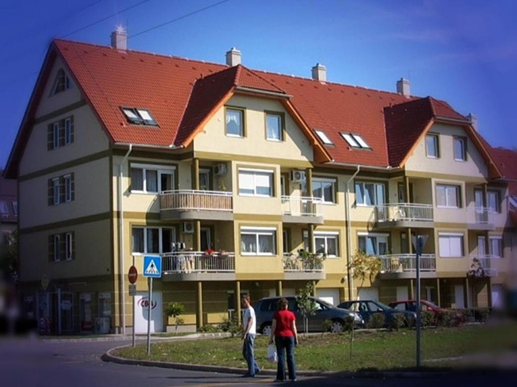 dos personas parados frente a un gran edificio en AAA-Apartment 2, en Balatonfüred