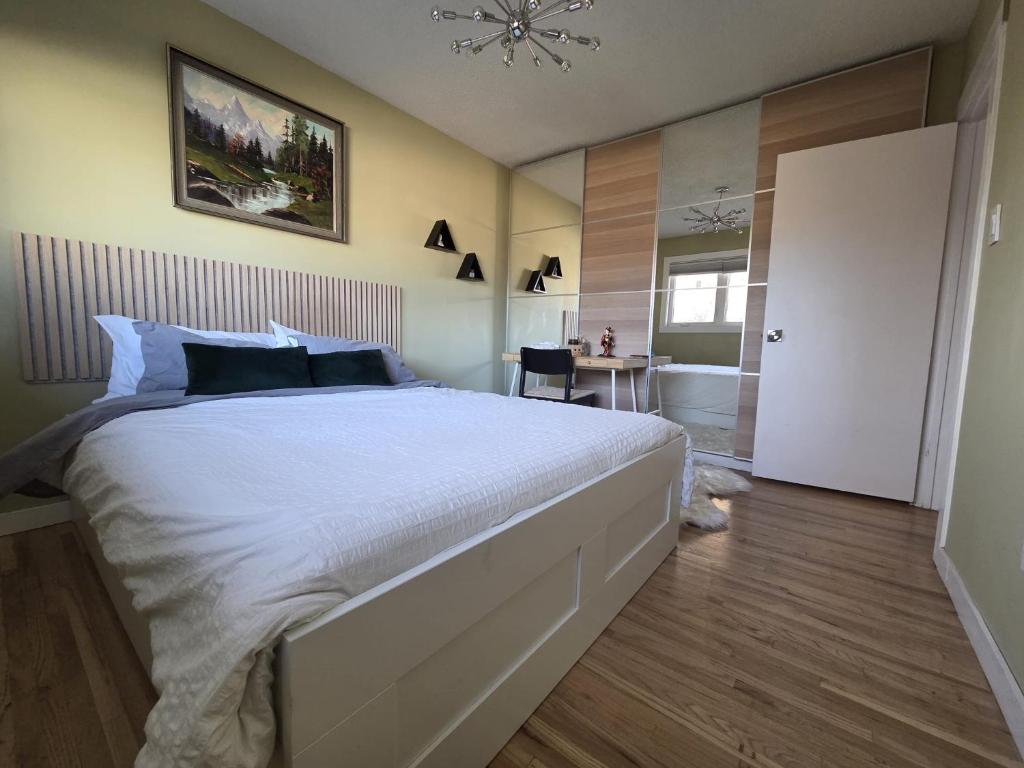 a bedroom with a large white bed and a desk at Room with Shared Bathroom - Stampede & Mountains in Calgary