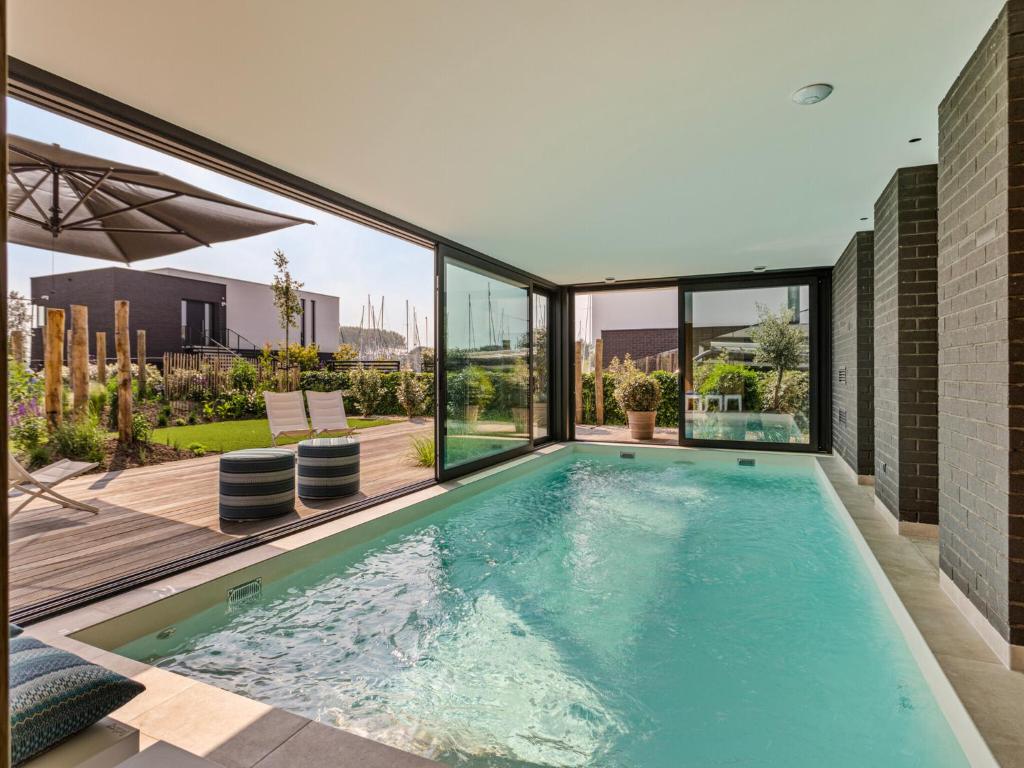 a swimming pool with a view of the city from a house at Zilte Watervilla in Kamperland