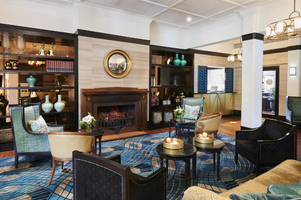a living room with a fireplace and chairs at Hotel Kurrajong Canberra in Canberra