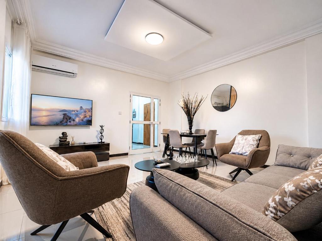 a living room with a couch and chairs and a table at Modern Central Studio - Dakar Plateau in Dakar