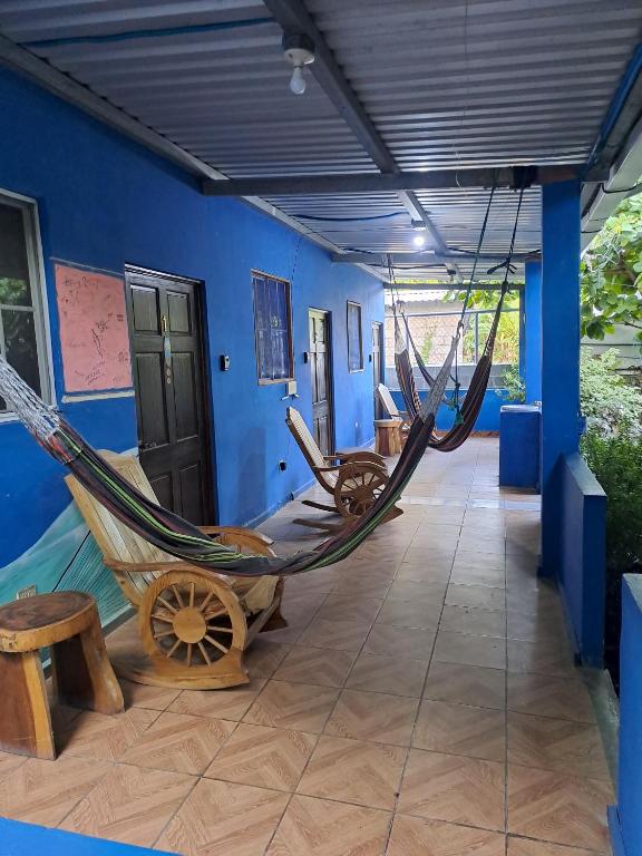 a room with two hammocks and a blue wall at Hostal Niña Oly in El Sunzal