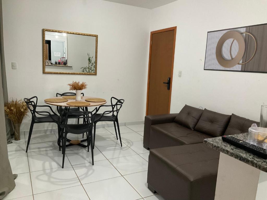 a living room with a table and a couch at Ap com 2 quartos climatizados , com fechadura eletrônica, WI-FI ,condomínio Village do bosque 3 in Imperatriz
