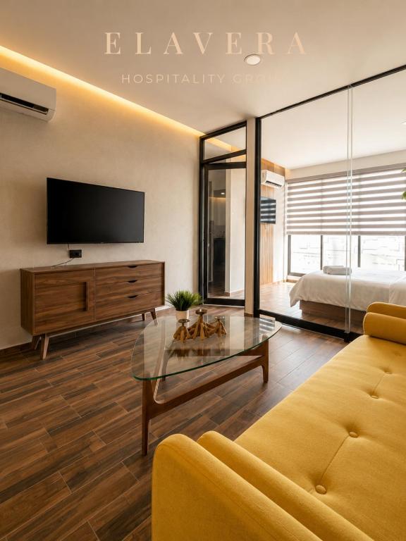 a living room with a tv and a couch and a bed at DG Comfort - Depart Privado con balcon in Villahermosa