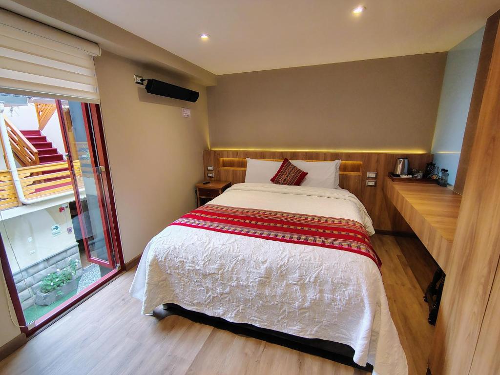 a bedroom with a large bed and a window at La Posada del Viajero in Cusco