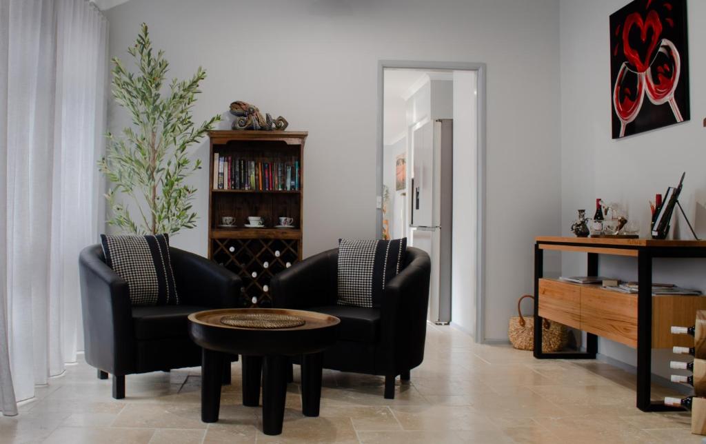 a living room with two chairs and a table at Koblenz Haus - “Heart of the Barossa” - (New Mgmt) in Tanunda