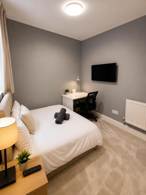 a bedroom with a bed and a desk and a television at Catherines House Kings Cross Area in London