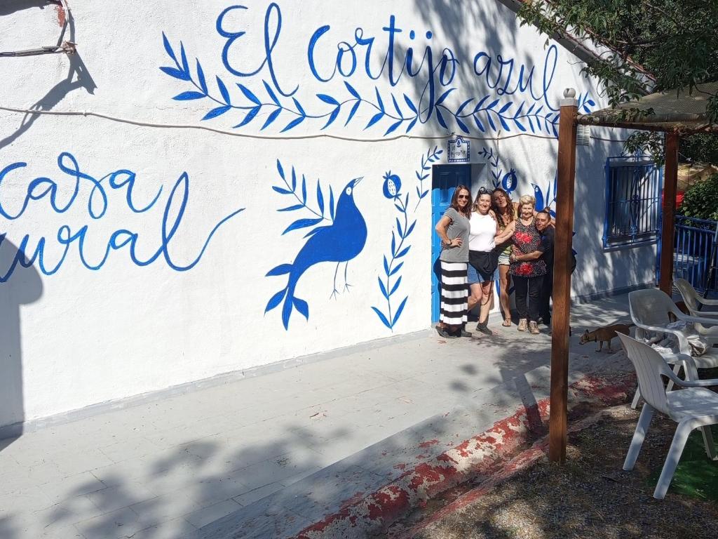 a group of people standing in front of a wall at El cortijo azul in Güéjar-Sierra