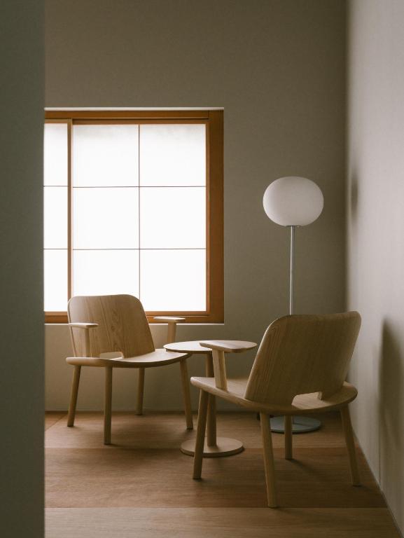 two chairs and a table in a room with a window at YALDA apartment in Kanazawa