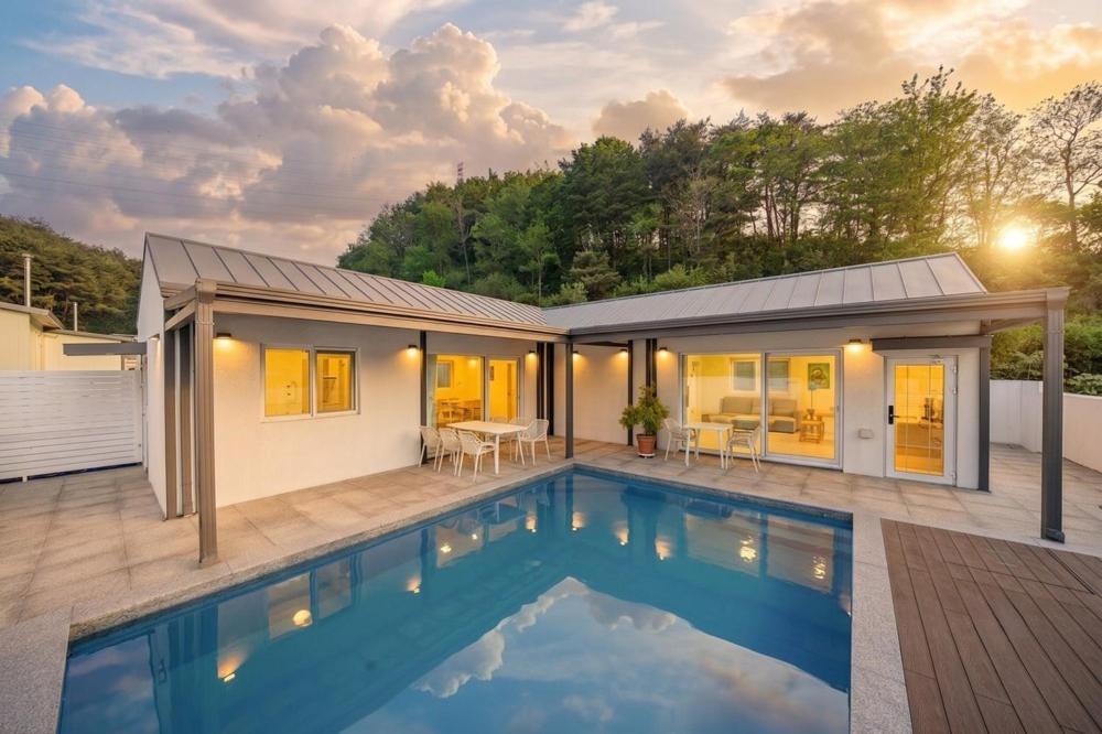 a house with a swimming pool in front of it at Yangyang Sonamu Private Pension in Yangyang